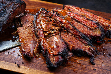 Modern style traditional smoked barbecue wagyu beef brisket served as top view on a wooden design...