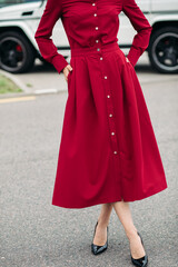 Woman in red posing in the street.