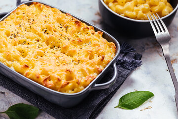 Mac and cheese baked in oven with basil leaves