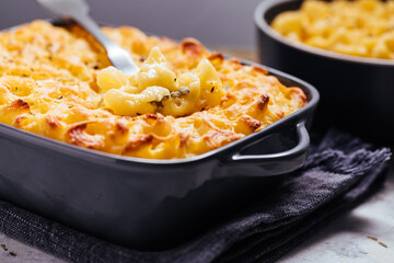 Mac and cheese baked in oven with basil leaves