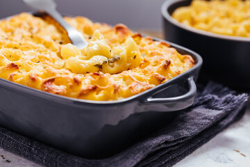 Mac and cheese baked in oven with basil leaves