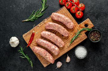 raw sausages for grilling on a stone background
