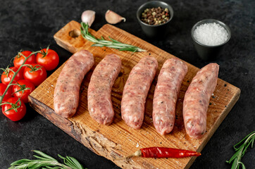 raw sausages for grilling on a stone background