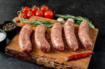 raw sausages for grilling on a stone background