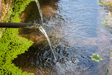 Pipe clean water pouring from a natural source