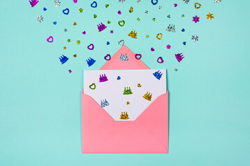 Pink Envelope with party confetti explosion on blue or turquoise background. Invitation card, flat lay