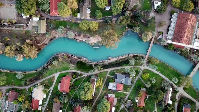 Aerial view flyover kibbutz Nir David, North of Israel. A view of farmland close to Beit shean valley with river channel dividing east and west side and Small Town With Red rooftops.