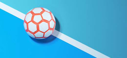 White and orange futsal ball on the indoor soccer field background with line and copy space