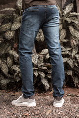 Męskie spodnie jeans niebieskie na modelu na naturalnym tle, zdjęcie reklamowe na baner. - obrazy, fototapety, plakaty