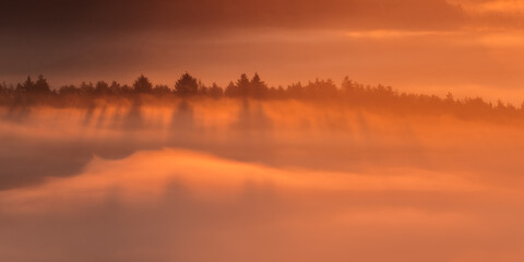 Sunrise over misty hills