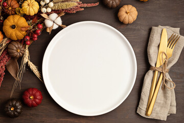 Rustic menu mockup with plate and autumn table decoration.  Floral interior decor for fall holidays with handmade pumpkins. Holiday dinner concept. Flatlay, top view. - Powered by Adobe
