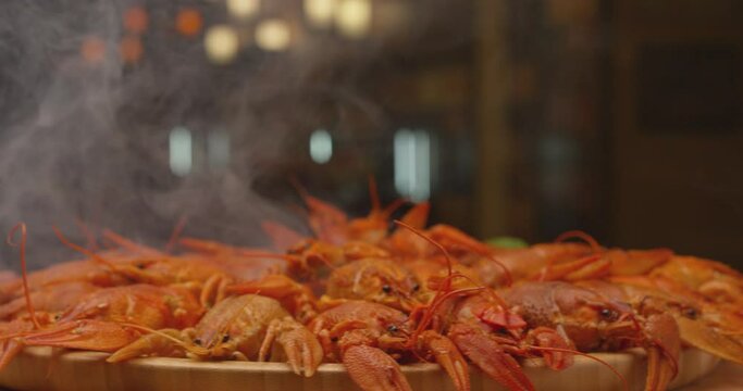 River boiled crayfish a good snack to beer. Waiter puts on the table a plate of boiled red river cancer . A plate of  fuming or smoking hot crawfish in the restaurant. Shot on RED Camera Slow motion. 