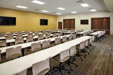 Modern office university conference meeting room with office chairs and tvs