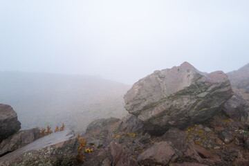 栃木県那須郡那須町の那須岳に霧の中で紅葉を見るために登山している風景 A view of climbing Mt. Nasu in Nasu-machi, Nasu-gun, Tochigi Prefecture, to see the autumn leaves in the fog.