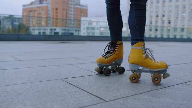 Unrecognizable girl making roller skating elements at rooftop in summer.