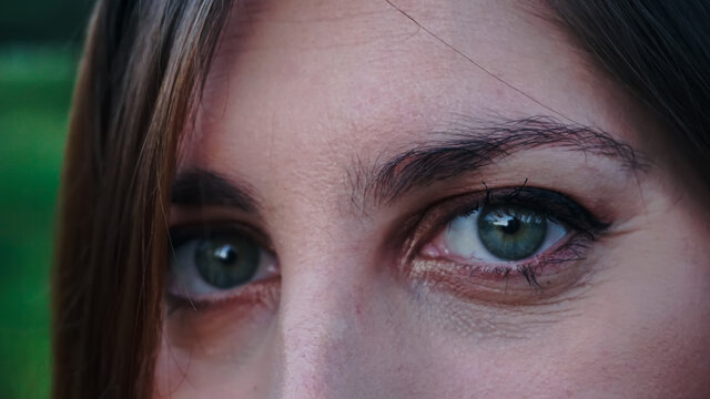 mujer joven de ojos verdes en el parque, mirada angelical de mujer blanca, ojos claros mirando con ternura