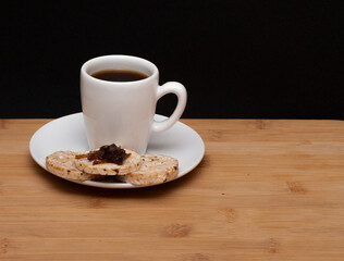 Obraz premium cup of coffe beside a rice vegan cookies with jelly on the top under the wood table