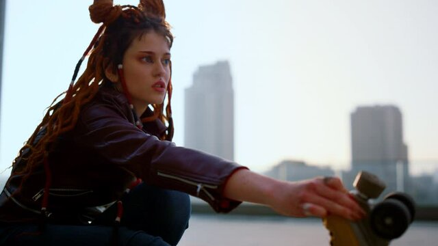 Young woman riding on rollerblades outside. Roller skater performing trick.