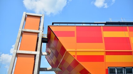 Modern facade of building , steel facade construction. Geometric color elements of the building's facade with planes and lines in red and orange colors.