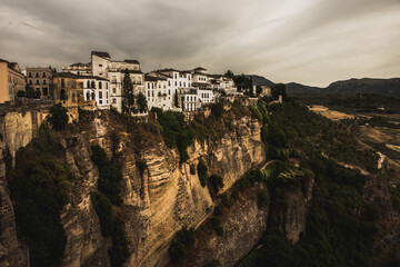 Fototapeta premium Ronda cliff and hanging houses with storm