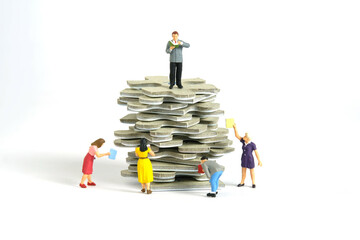 Miniature people toy figure photography. A group of student standing above puzzle jigsaw stack,...
