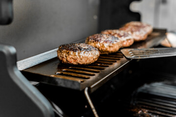 Rindfleisch Burger für Hamburger auf dem Grill mit Käse und Zwiebeln überbacken