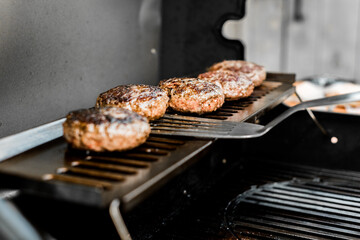 Rindfleisch Burger für Hamburger auf dem Grill mit Käse und Zwiebeln überbacken