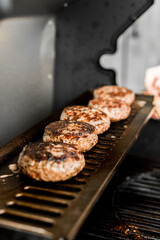 Rindfleisch Burger für Hamburger auf dem Grill mit Käse und Zwiebeln überbacken