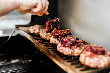 Rindfleisch Burger für Hamburger auf dem Grill mit Käse und Zwiebeln überbacken