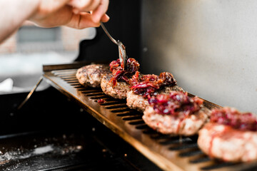 Rindfleisch Burger für Hamburger auf dem Grill mit Käse und Zwiebeln überbacken