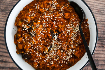 vegan eggplant and red lentil curry with sesame seeds topping, healthy plant-based food