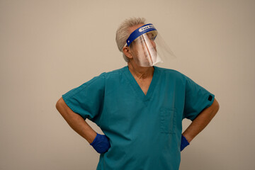 Male nurse with face mask shield and hands on hips akimbo