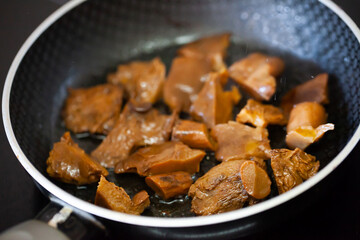 Fried mushrooms (Lactarius deliciosus) in frying pan. Roasting the chopped mushrooms in oil