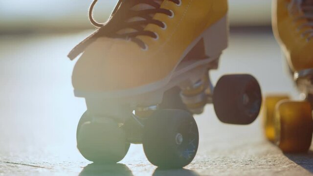 Yellow rollerblades for unknown female skater staying outdoors. Sports concept.