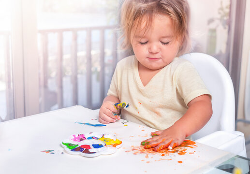 The child draws with paints