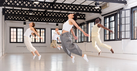 Group of dancers jumping during their training in ballroom