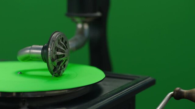 Vintage gramophone . Vintage old gramophone plays a vinyl record on green screen background . Wooden case turntable . Vinyl phonograph . Shot on ARRI ALEXA Cinema Camera in slow motion .