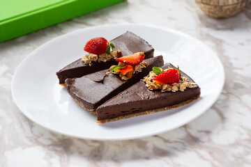 Three chocolate cakes and strawberries on wooden table