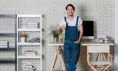 Young hipster beard Asian man standing  with happy in his new modern minimal startup office, concept for happy businessman with small business starting