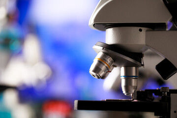 Closeup shot of microscope with selective lens objectives for various magnification or observation scales used as apparatus in microbiology lab for physical substance research and cell study.