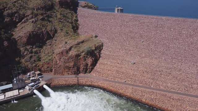 an aerial descending clip of the water outlet of lake argyle dam hydroelectric power station near kununurra in western australia