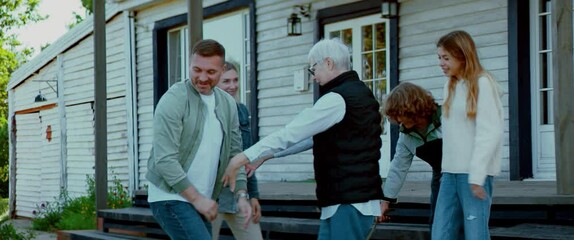Grandmother greeting her family with grandchildren on a doorstep of her rural house. Shot with 2x anamorphic lens