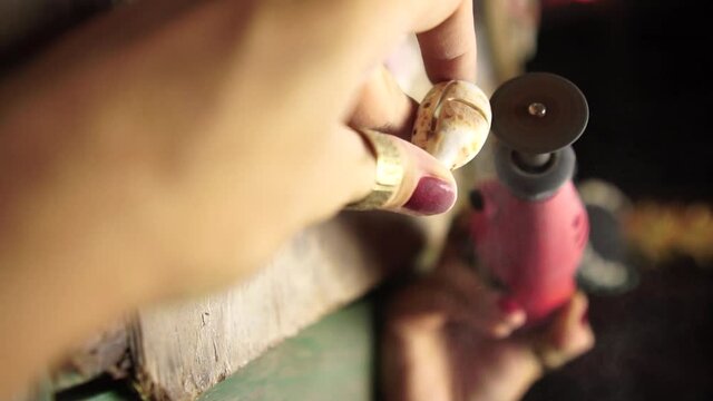 4K shaping of sea shell Grinder Polishing by hand craft handmade jewelry rough stone process. concept of jewelry making from sea shell