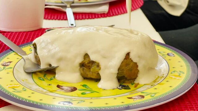 Authentic "Chile Relleno" being covered by wilnut sauce