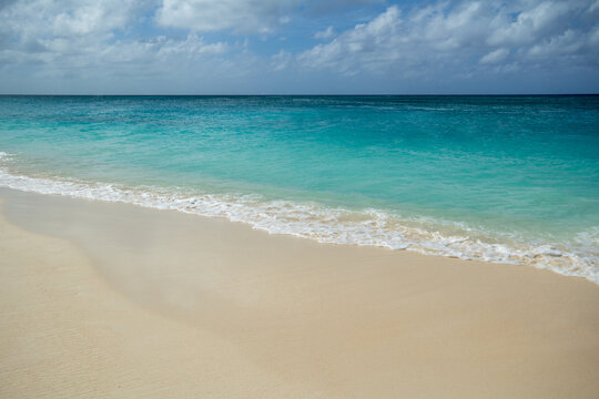 Soft foamy waves forming on a peaceful and relaxing sandy Beach in Grand Caymen.  