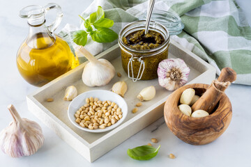 A tray of ingredients used to make homemade pesto sauce.