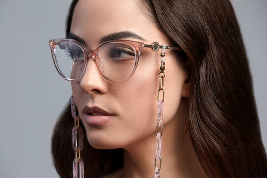 Portrait Of A Beautiful Brunette Woman In Glasses Close-up, Attractive Woman In Stylish Glasses On A Gray Background With Healthy Beautiful Color Skin, Gray Background, Copy Space