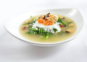 stir fried mixed vegetables spinach with 3 salted eggs in hot soup in white background asian halal menu
