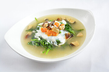 stir fried mixed vegetables spinach with 3 salted eggs in hot soup in white background asian halal menu