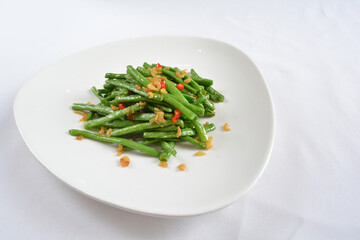 stir fried long green bean vegetables with dried shrimp in soy sauce in white background asian halal menu